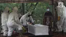 Petugas memakamkan jenazah Dedi Yuliardi Ashadi atau Dorce Gamalama di TPU Bantar Jati, Bambu Apus, Jakarta, Rabu  (16/2/2022). Ia berpulang setelah terpapar virus COVID-19. Dorce dimakamkan menggunakan protokol COVID-19 di TPU Bantar Jati, Bambu Apus. (Liputan6.com/Herman Zakharia)