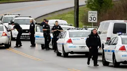 Petugas kepolisian menyisir area hutan untuk mencari tersangka penembakan di sebuah restoran Waffle House dekat Nashville, Tennessee, Minggu (23/4). Polisi mengatakan pelaku melepaskan jaketnya dan kabur dengan berjalan kaki. (AP Photo/Mark Humphrey)