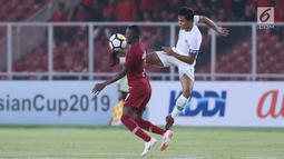 Bek Timnas Indonesia U-19, Rachmat Irianto (kanan) berebut bola dengan pemain Qatar U-19, Abdulrasheed Umaru pada penyisihan Grup A Piala AFC U-19 2018 di Stadion GBK, Jakarta, Minggu (21/10). Indonesia kalah tipis 5-6. (Liputan6.com/Helmi Fithriansyah)
