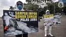 Aktivis membawa poster saat aksi "Sampah Impor Bunuh Sungai Pulau Jawa" di kawasan Patung Kuda, Monas, Jakarta, Senin (3/5/2021). Limbah buangan pabrik merusak ekosistem sistem sungai dan menimbulkan racun. (merdeka.com/Iqbal S. Nugroho)