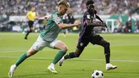 Bek Werder Bremen, Mitchell Weiser berbeut bola dengan bek Bayern Munchen Alphonso Davies dalam laga pekan ke-1 Bundesliga 2023/2024 di Stadion Wesser, Sabtu (19/8/2023) dinihari WIB. (Axel Heimken/dpa via AP)