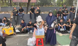 Pedagang menjajakan air mineral dan kopi di tengah demonstrasi di kawasan Senayan, Jakarta Pusat, Kamis (27/8/2026). (Liputan6.com/Christian)