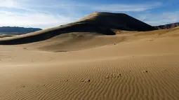 Jejak kaki terlihat di atas bukit pasir Taman Nasional Altynemel, Almaty, Kazakhstan, 12 Mei 2016. Bukit pasir yang membentang hingga 3 km dan tinggi 30 m ini dapat menghasilkan gemuruh bernada rendah yang seolah-olah bernyanyi (REUTERS/Shamil Zhumatov)