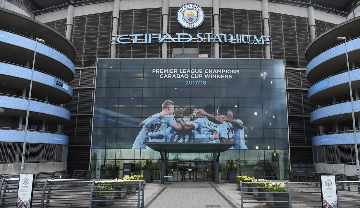 Poster raksasa bergambar pemain Manchester City terpasang di Stadion Etihad, Manchester, Senin (17/4/2018). Persiapan ini dilakukan untuk merayakan pesta juara Manchester City meraih gelar Premier League. (AFP/Paul Ellis)