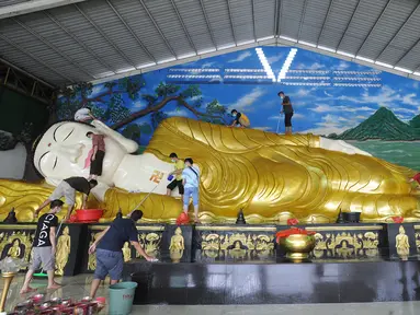 Umat membersihkan patung Buddha tidur raksasa di Vihara Buddha Dharma dan 8 Posat, Bogor, Jawa Barat, Minggu (7/2/2021). Patung buddha tidur raksasa sepanjang 18 meter dan tinggi 5 meter tersebut dibersihkan setiap tahun menjelang Tahun Baru Imlek. (merdeka.com/Arie Basuki)
