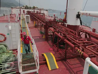 Pekerja melakukan pengecekan kapal M.T Jhon Caine yang digunakan untuk menyuplai BBM di Terminal BBM Panjang, Bandar Lampung, Selasa (6/10/2015). Terminal BBM Panjang akan menjadi Integrated End to End Pertama di Indonesia. (Liputan6.com/Angga Yuniar)