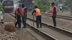 Petugas melakukan perawatan jalur rel kereta api di Buaran Pondok Kopi, Jakarta, Kamis (13/9). Perawatan dilakukan untuk menjamin keselamatan perjalanan kereta dan mencegah terjadi amblesnya bantalan rel. merdeka.com/imam buhori