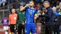 Striker Timnas Bosnia-Herzegovina, Edin Dzeko, mengenakan jersey biru produksi Kelme di laga Kualifikasi Euro 2024. (ELVIS BARUKCIC / AFP)
