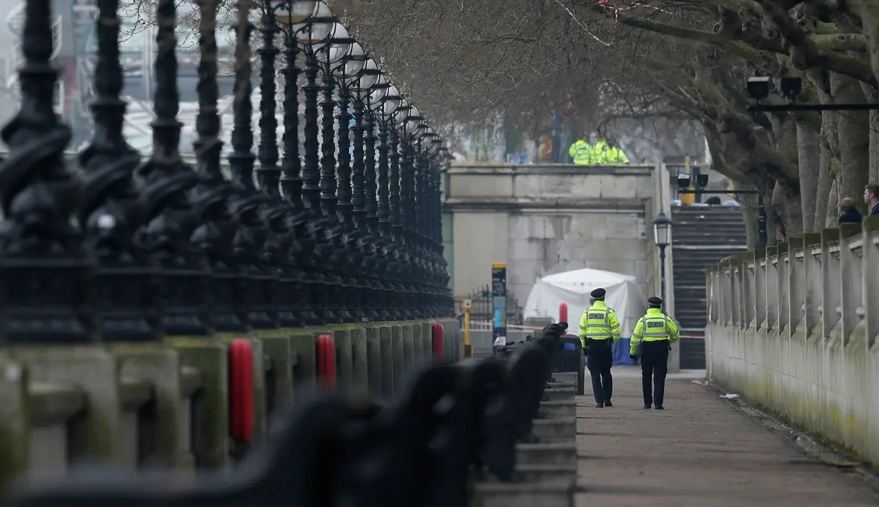 Polisi mengamankan lokasi serangan teror saat forensik melakukan penelitian di dekat gedung parlemen di London, Rabu (22/3). Sedikitnya lima orang tewas dalam serangan teror di Jembatan Westminster dan di dekat Gedung Parlemen itu. (AP Photo/Tim Ireland)