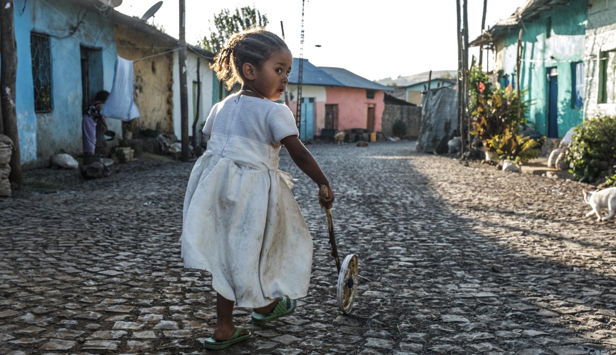 Seorang anak bermain di sebuah jalan di Kota Gondar, Ethiopia pada 09 November 2020. (Photo by EDUARDO SOTERAS / AFP)