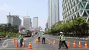 Seorang petugas kepolisian terlihat mengatur ruas jalan sekitar patung kuda, Jakarta, Selasa (1/8/2015). Hari ini ratusan buruh berkumpul di Patung Kuda untuk mengadakan aksi unjuk rasa hingga ke Istana Merdeka. (Liputan6.com/Gempur M Surya)