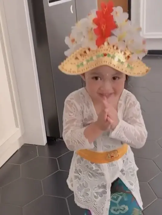 <p>Anak Fitri Tropica pun tampil menggemaskan dengan kebaya putih khas Bali, dilengkapi obi kuning berdetail bunga. Dipadukan kain lilit warna biru, ia juga lengkap mengenakan hiasan kepala.(@fitrop)</p>