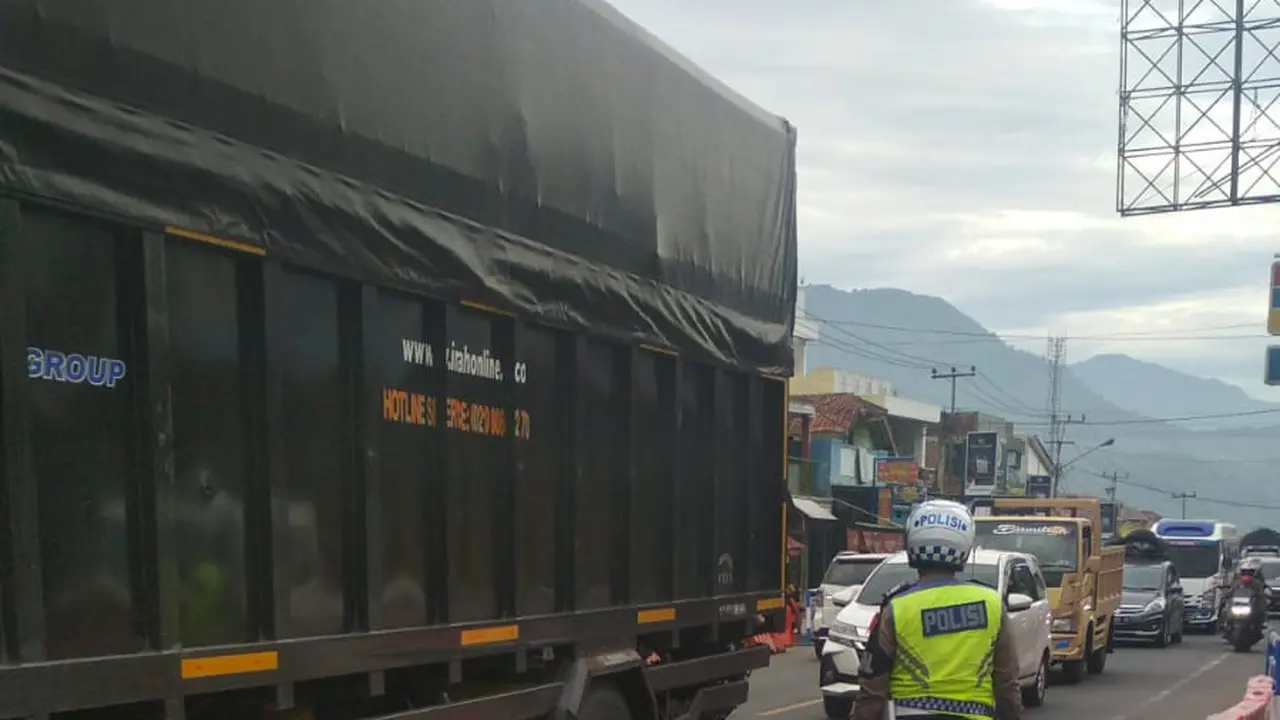 Nampak seorang petugas tengah mengamankan jalur dengan penarapan one way di lajur Limbangan-Malangbong, Garut, Jawa Barat. (Liputan6.com/Jayadi Supriadin)