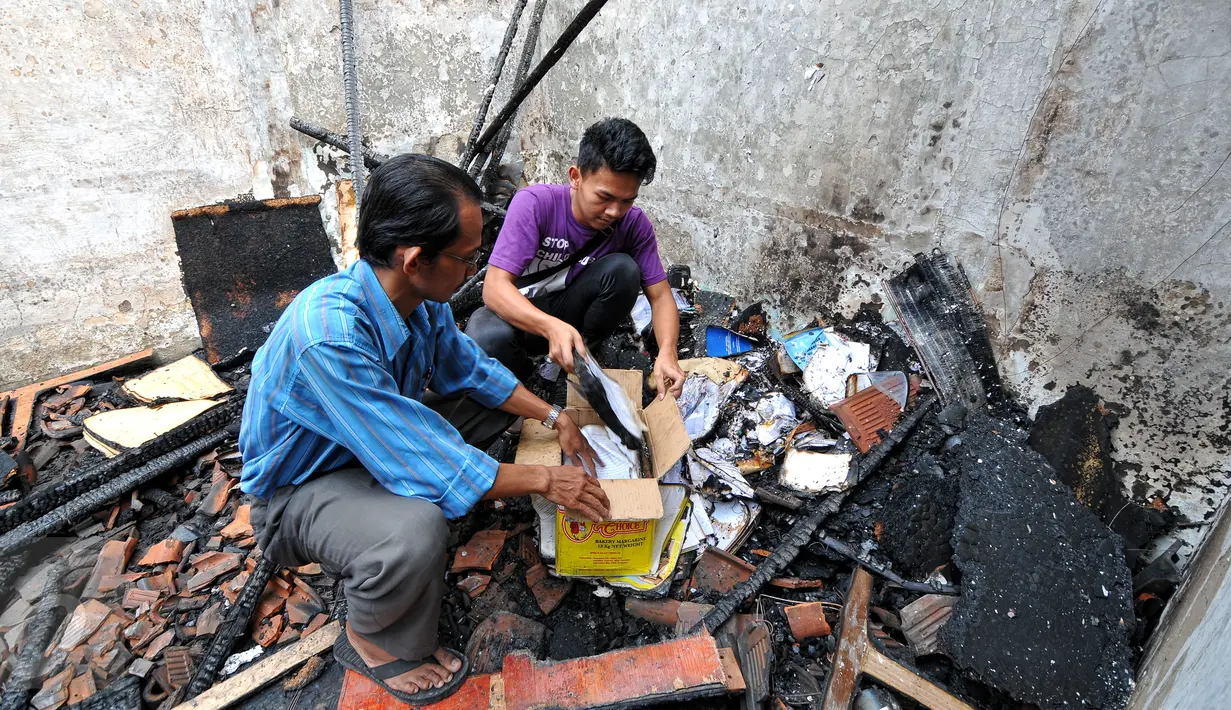 Dua orang petugas berusaha menyelamatkan sisa-sisa dokumen di satu ruangan Kantor Komisi Nasional Perlindungan Anak pasca terbakar, Jakarta, Senin (29/6/2015). Polisi masih terus menelusuri penyebab terjadinya kebakaran. (Liputan6.com/Yoppy Renato)