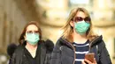 Dua wanita mengenakan masker berjalan di Milan, Italia (24/2/2020). Kepala Departemen Perlindungan Sipil sekaligus Komisaris Luar Biasa untuk Darurat Coronavirus, Angelo Borrelli mengatakan enam orang meninggal dan 222 lainnya teruji positif infeksi COVID-19 di Italia. (Xinhua/Daniele Mascolo)