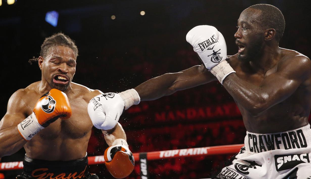 Terence Crawford (kanan) memukul Shawn Porter pada pertandingan tinju perebutan gelar juara dunia kelas welter WBO di Las Vegas, Amerika Serikat, 20 November 2021. Terence Crawford menang TKO pada ronde 10. (AP Photo/Chase Stevens)