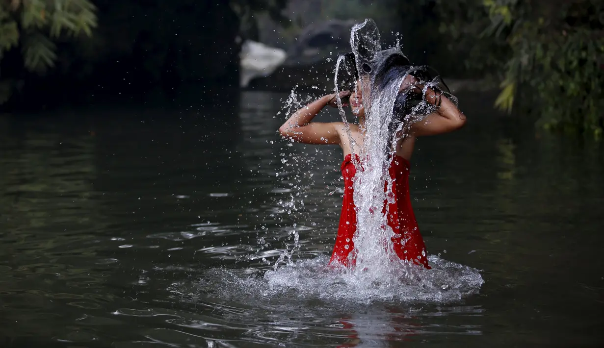 Wanita Hindu Nepal mandi suci disungai Salinadi saat Festival Swasthani Brata Katha di Katmandu, Nepal, (24/1). Selama festival ini, para wanita yang belum menikah berdoa untuk mendapatkan suami yang baik. (REUTERS/Navesh Chitrakar)