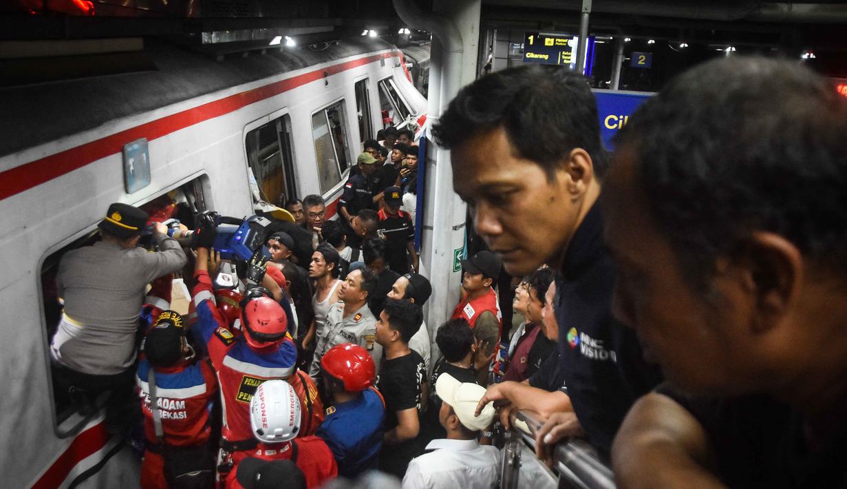 Para petugas penyelamat bekerja di lokasi tabrakan kereta api setelah lokomotif kereta penumpang menembus gerbong belakang kereta komuter di stasiun Bekasi Timur, Bekasi, Jawa Barat pada 28 April 2026. (Foto oleh Rezas / AFP)