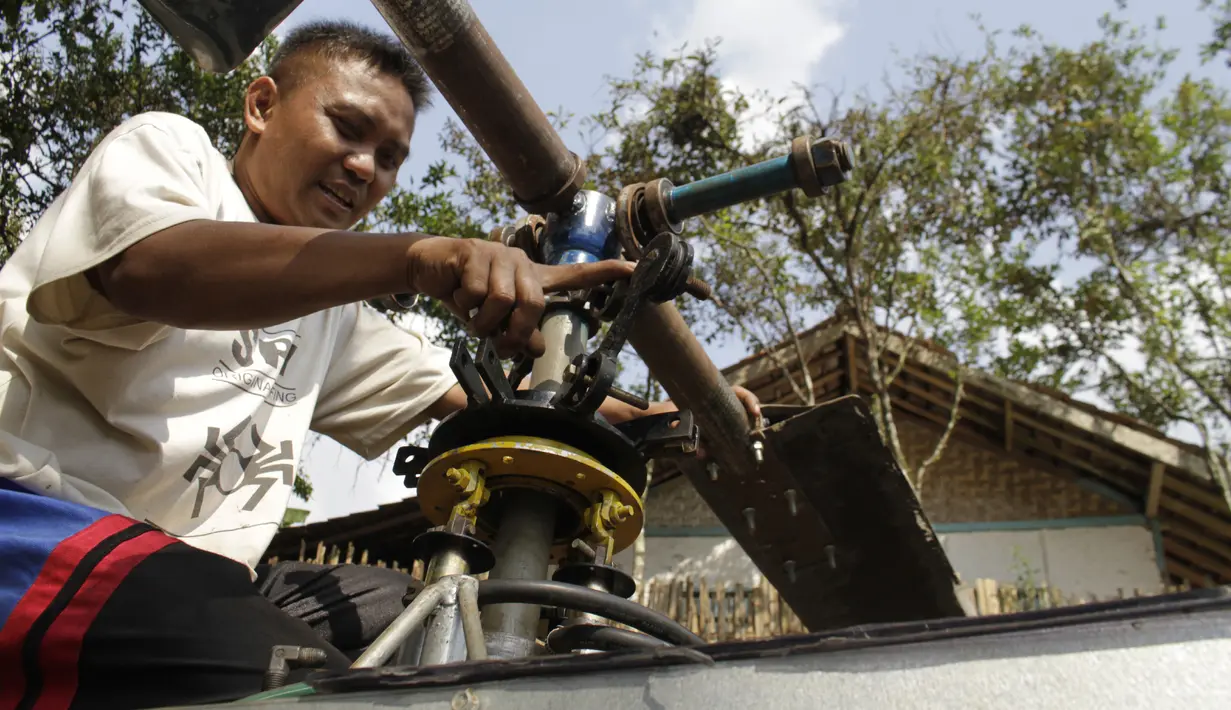 Gambar yang diambil pada 17 November 2019, Jujun Junaedi menyelesaikan pembuatan helikopter buatannya di halaman belakang rumahnya di Sukabumi. Jujun merogoh kocek hingga lebih dari RP 30 juta rupiah untuk merakit helikopter bermesin genset dua silinder 700 cc ini. (Wulung WIDARBA/AFP)