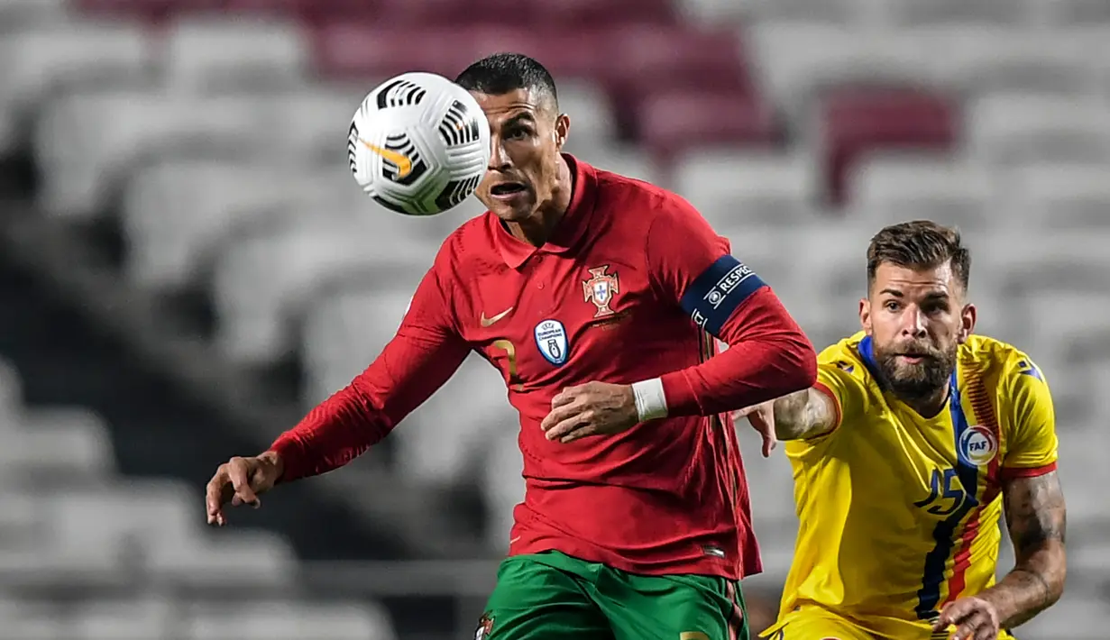 Pemain depan timnas Portugal, Cristiano Ronaldo (kiri) berebut bola dengan gelandang timnas Andorra, Moises San Nicolas dalam pertandingan uji coba internasional di Estadio da Luz, Kamis (12/11/2020) dini hari WIB. Portugal menang 7-0 atas tamunya, Andorra. (PATRICIA DE MELO MOREIRA / AFP)