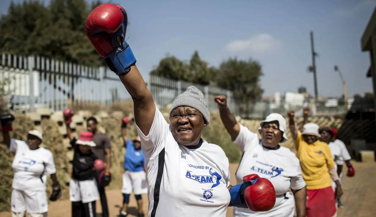 Para nenek pemanasan sebelum latihan tinju pada Boxing Gogos di Cosmo City, Johannesburg, Selasa (19/9/2017). Berkat latihan rutin yang dipimpin Claude Maphosa ini para lansia berhasil sembuh dari penyakit dan hidup lebih sehat. (AFP/Gulshan Khan) 
