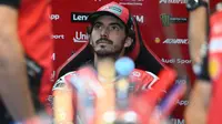 Pembalap MotoGP Italia dari Tim Ducati Lenovo, Francesco Bagnaia, mendengarkan seorang mekanik selama sesi latihan menjelang Grand Prix MotoGP Valencia di sirkuit Ricardo Tormo di Cheste pada 15 November 2025. (Jose Jordan/AFP)