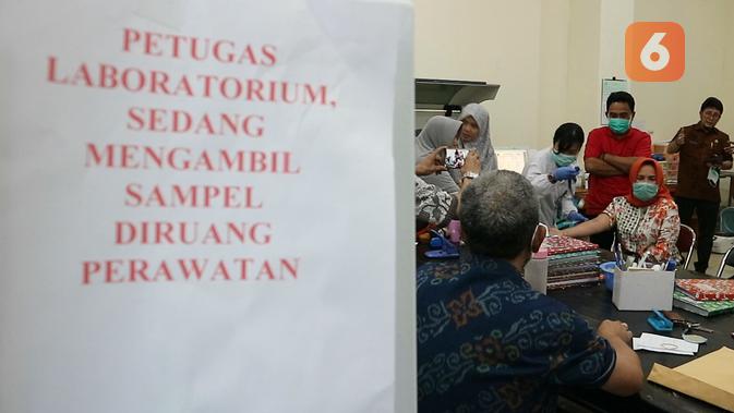 Petugas laboratorium RSUD Anutapura Palu sedang mengambil sampel darah warga untuk diperiksa untuk mengetahui kondisi kesehatannya. (Foto: Liputan6.com/ Heri Susanto).