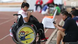 Atlet dan official tim China beraktivitas dengan ponsel mereka di kawasan Stadion Madya Kompleks Gelora Bung Karno, Jakarta, Kamis (11/10). Berbagai aktivitas dilakukan para atlet para atletik di luar arena. (Liputan6.com/Helmi Fithriansyah)