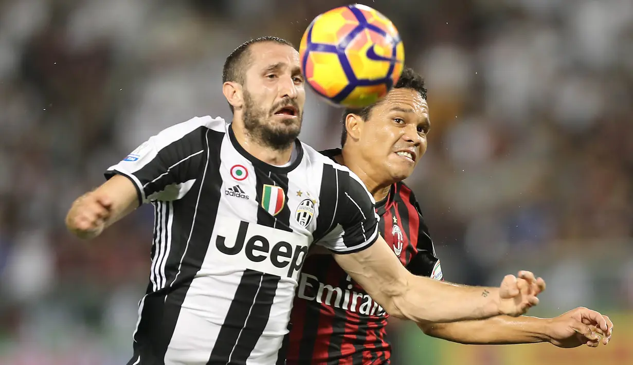 Bek Juventus, Giorgio Chiellini, duel udara dengan striker AC Milan, Carlos Bacca, pada laga Piala Super Italia 2016. Pada laga ini Juventus sebagai pemuncak klasemen Serie A lebih diunggulkan untuk meraih gelar. (AFP/Karim Jaafar)