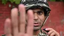 Personel militer memberi isyarat saat berjaga-jaga di sepanjang jalan selama jam malam yang diberlakukan untuk memulihkan ketertiban dan keamanan di Kathmandu, Nepal pada 12 September 2025. (Pedro Pardo/AFP)