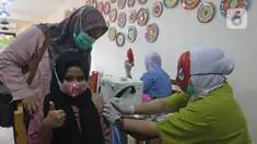 Seorang anak disuntik vaksin covid-19 oleh tenaga kesehatan bertopeng superhero saat vaksinasi anak usia 6-11 tahun di RSIA Tambak, Jakarta, Rabu (22/12/2021). Penggunaan topeng superhero dimaksudkan untuk menarik minat anak-anak yang mengikuti vaksinasi. (lLiputan6.com/Herman Zakharia)