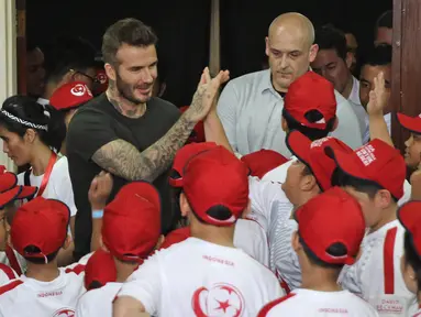 Mantan bintang sepak bola Inggris David Beckham menyapa anak-anak pada acara AIA Sepak Bola untuk Negeri di Jakarta, Minggu (25/3). David tampil di Stadion Soemantri Brodjonegoro dengan membagikan 10 ribu bola. (Liputan6.com/Herman Zakharia)