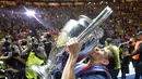 Ekspresi Lionel Messi  saat mencium trofi Liga Champions yang berhasil diraihnya kembali bersama Barcelona. (AP Photo/Martin Meissner)