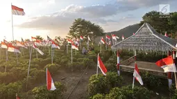 Wisatawan berjalan di antara ribuan bendera Merah Putih di perkebunan teh Kemuning, Karanganyar, Jateng, Sabtu (25/8). 1.970 bendera Merah Putih, diantaranya 17 berukuran sedang, 8 besar, dan 1.945 kecil dikibarkan. (Merdeka.com/Iqbal S. Nugroho)