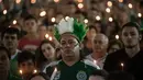 Seorang fans Chapecoense dengan penutup kepala berbulu memperingati satu tahun kecelakaan pesawat Lamia 2933 di Arena Conda stadium, Chapeco, Santa Catarina, Brasil, (28/11/2017). Sekitar 19 pemain Chapecoense meninggal. (AFP/Nelson Meida)