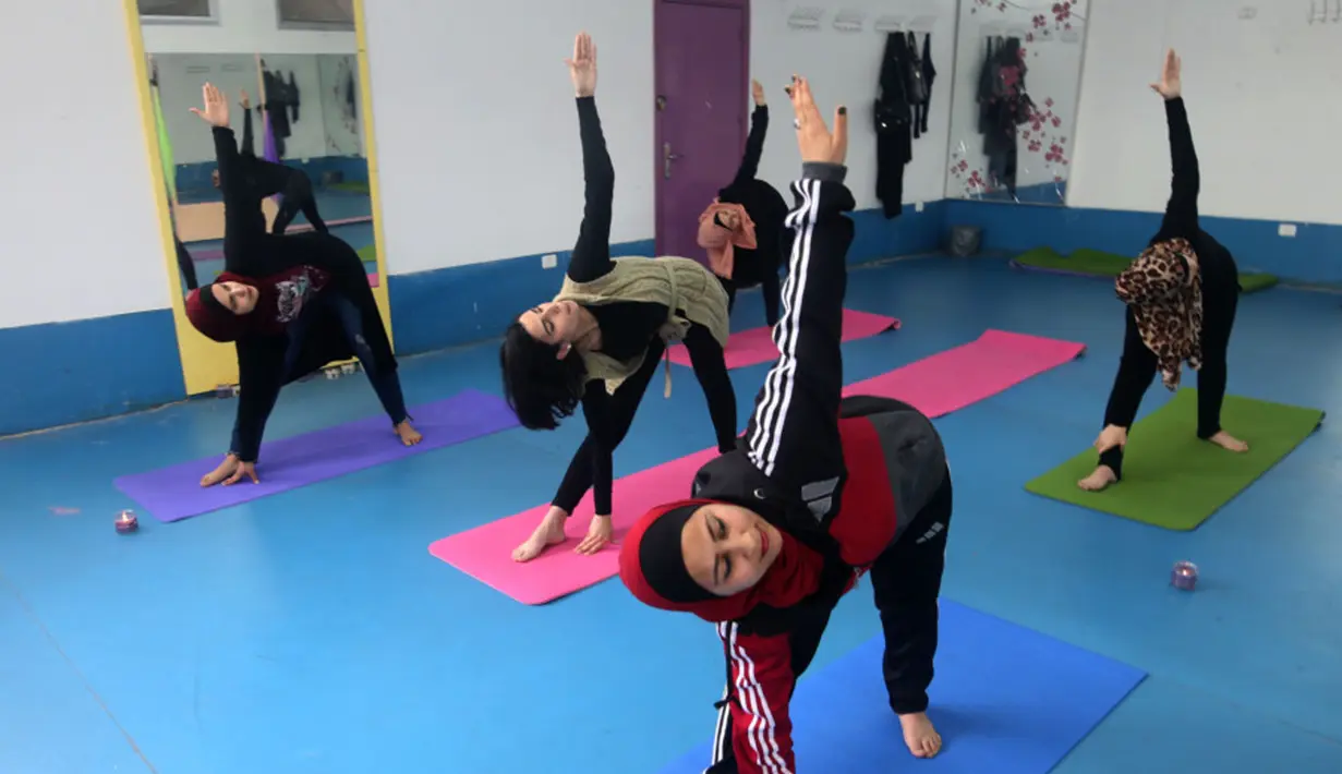 Wanita Palestina mengikuti sesi latihan yoga di pusat pelatihan yoga wanita pertama di kota Gaza, 28 Maret 2018. Mereka belajar yoga untuk membantu warga lain menghadapi stres dan trauma karena tinggal di kawasan dalam sengketa. (MOHAMMED ABED/AFP)