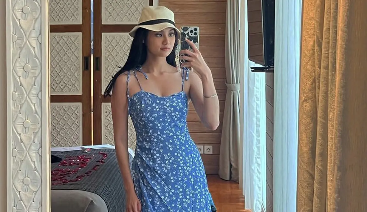 Gege juga tampil mengenakan slit dress heart neck warna biru bermotif bunga. Dipadukan topi pantainya. Credit: @gegeelisa94