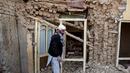 Seorang penyintas gempa bumi Afghanistan berjalan melewati reruntuhan rumah yang rusak di sebuah desa di Tashqurghan, distrik Khulm, provinsi Samangan, pada Senin 3 November 2025. Jumlah korban diperkirakan akan terus bertambah seiring berlanjutnya upaya penyelamatan. (Atif Aryan/AFP)