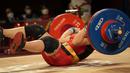 Hoang Thi Duyen dari Vietnam terjatuh saat bertanding di cabang angkat besi 59kg putri Olimpiade Tokyo 2020, Selasa (27/7/2021). (Foto: AP/Luca Bruno)
