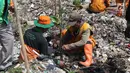 Petugas Sudin Lingkungan Hidup bersama PPSU menanam bibit pohon mangrove di atas tumpukan sampah di kawasan hutan mangrove Ecomarine, Jakarta Utara, Minggu (18/3). Mangrove sangat diperlukan untuk menahan abrasi. (Liputan6.com/Arya Manggala)