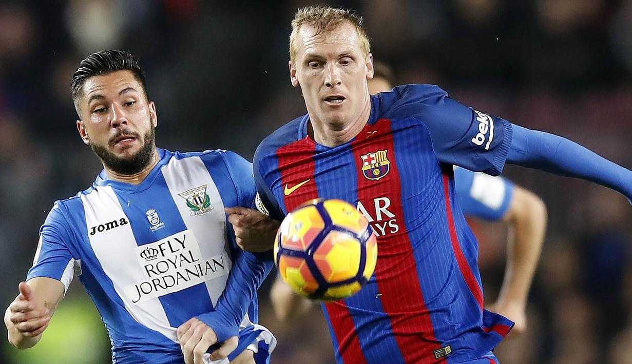 Bek Barcelona, Jeremy Mathieu, berebut bola dengan penyerang Leganes, Miguel Angel Guerrero. Pada laga ini Barca menggunakan formasi 4-3-3, sementara Leganes memakai skema 4-5-1. (EPA/Alberto Estevez)