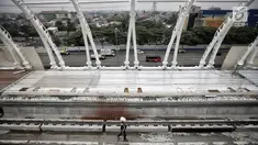 Petugas keamanan melintas di proyek pembangunan Light Rail Transit (LRT) Jabodebek di Stasiun LRT TMII, Jakarta, Senin (14/1). Progres pembangunan Stasiun LRT TMII sudah mencapai 40%. (Liputan6.com/Faizal Fanani)