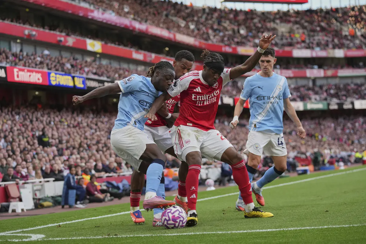 Noni Madueke (kedua dari kanan) berebut bola dengan Jeremy Doku di laga Arsenal vs Manchester City di Emirates Stadium, Minggu (21/09/2025). (AP Photo/Kin Cheung)