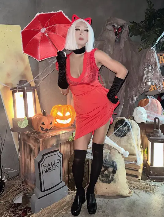 Seperti potret ini, ia tampil mengenakan dress merah dan payudara palsu, lengkap dengan wig-nya. [@amingisback].