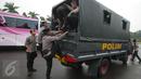 Petugas kepolisian menaiki truk pengangkut saat melakukan pengamanan di kawasan Monas, Jakarta, Selasa (18/4). Polda Metro Jaya dan Kodam Jaya mengerahkan 64.523 personel gabungan untuk mengawal Pilkada DKI 2017 putaran kedua. (Liputan6.com/Faizal Fanani)