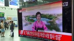 Warga menonton penyiar berita Korea Utara, Ri Chun-Hee menginformasikan berita tentang tes ICBM baru di stasiun kereta di Seoul pada 4 Juli 2017. Saat itu Korut memproklamirkanelah berhasil menguji rudal balistik antar benua. (AFP Photo/Jung Yeon-Je)