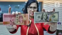 Teller menunjukkan mata uang rupiah dan dolar AS di Jakarta, Selasa (31/10/2023). Pada penutupan perdagangan hari ini, mata uang rupiah menguat sebesar 5 poin atau 0,03 persen menjadi Rp 15.885 per dolar AS dari penutupan sebelumnya sebesar Rp 15.890 per dolar AS. (Liputan6.com/Angga Yuniar)