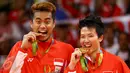 Pasangan ganda campuran Indonesia, Tontowi Ahmad dan Liliyana Natsir mengigit medali emas usai mengalahkan lawannya asal Malaysia Peng Soon Chan dan Liu Ying Goh pada final bulutangkis di Riocentro Pavilion 4 , Brasil. (REUTERS/Mike Blake)