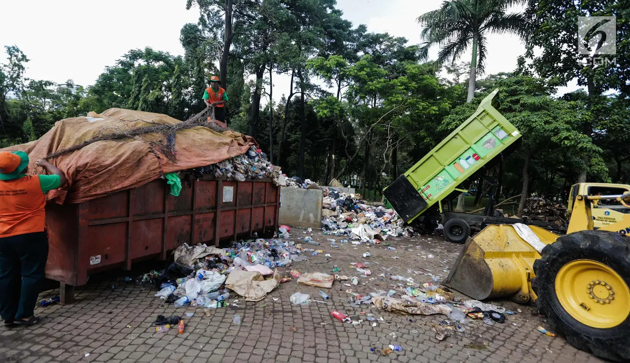 Petugas kebersihan membersihkan tumpukan sampah Tahun Baru 2018 di Monas, Jakarta, Senin (1/1). Setelah perayaan malam tahun baru 2018, jumlah sampah sisa mencapai 780 ton. (Liputan6.com/Faizal Fanani)