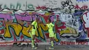 Sebuah lomba lari bertajuk "100 Meilen Berlin 2014" akan digelar di sepanjang Tembok Berlin. Tampak, Martina Schliep (kanan) dan Gaston Pruefer melakukan pemanasan sebelum latihan lari di sisi timur Tembok Berlin, (11/8/2014). (AFP PHOTO/Tobias Schwarz)